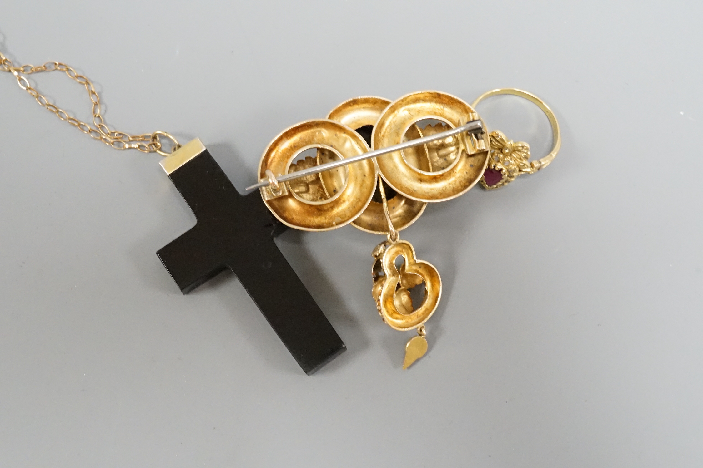 A Victorian yellow metal and garnet cluster set drop brooch, 50mm, a modern 18ct gold, ruby and diamond heart shaped ring with ribbon bow crest and a micro mosaic set cross pendant, on a 9k chain.